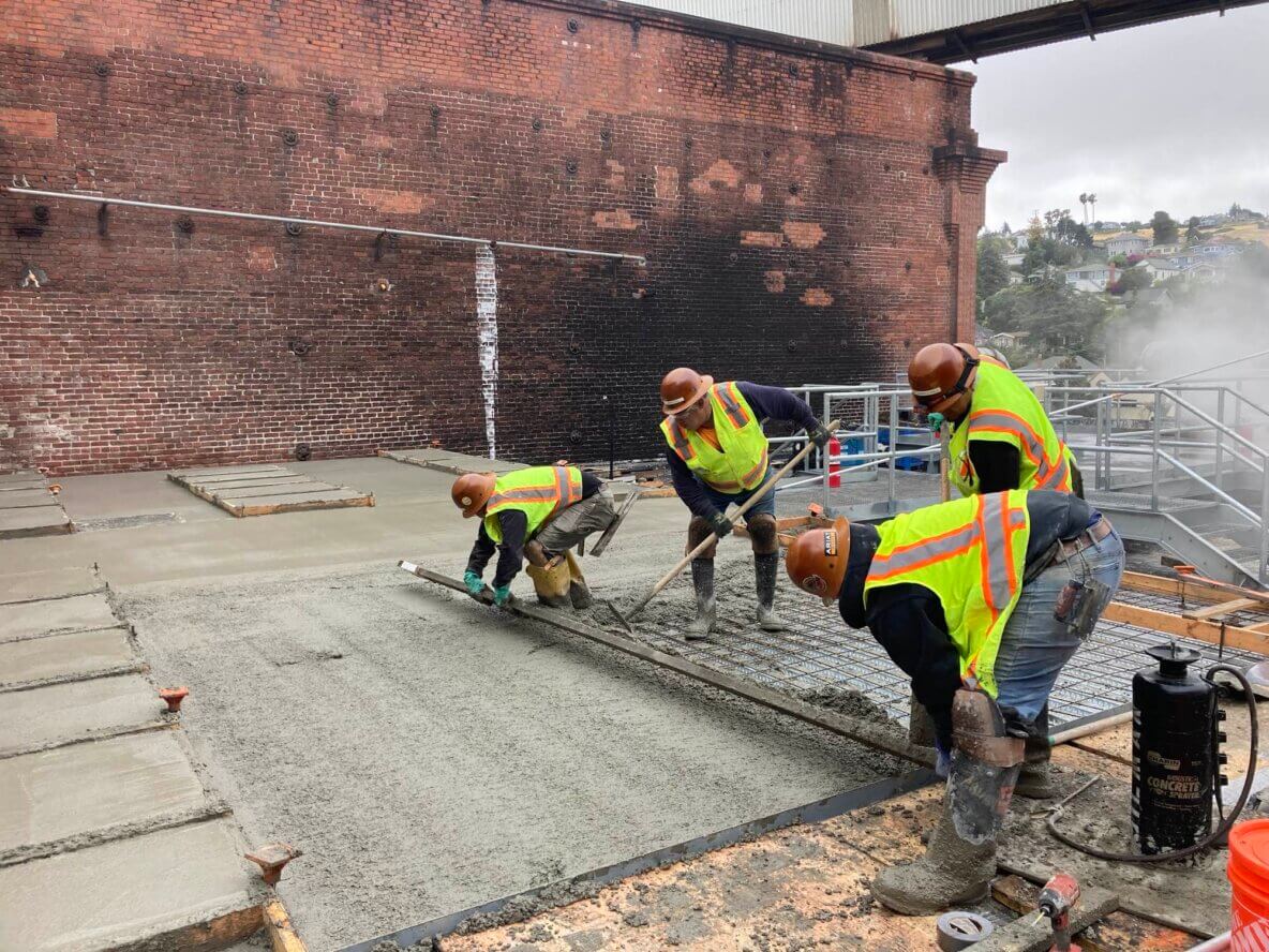 civil construction team pouring concrete on mezzanine